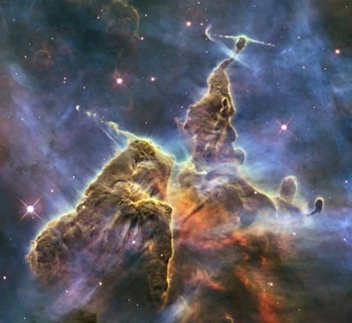 NASA space photograph of towering clouds of gas against a field of stars.