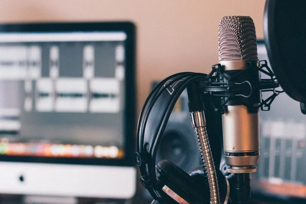 Studio microphone and pop filter beside recording equipment.
