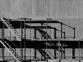 Scaffolding against a grey concrete background in an urban environment.