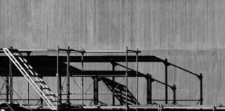 Scaffolding against a grey concrete background in an urban environment.