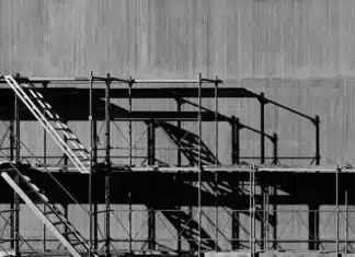 Scaffolding against a grey concrete background in an urban environment.