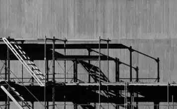 Scaffolding against a grey concrete background in an urban environment.