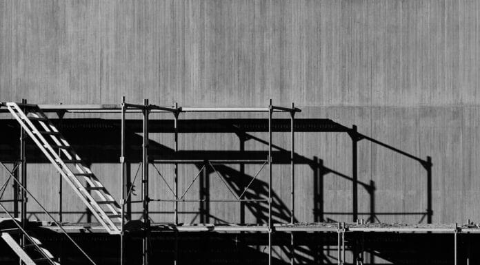 Scaffolding against a grey concrete background in an urban environment.